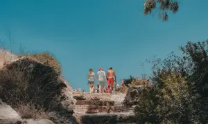 Spacer po kamiennych schodach w górach Troodos. Słoneczny dzień, błękitne niebo i bujna roślinność.