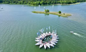 Żeglarska feta na Mazurach! Jachty tworzą krąg, a w tle las i jezioro. Idealne miejsce, by zapytać: gdzie na Mazury?