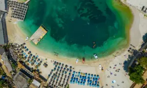 Rajska plaża w Albanii, idealne miejsce na wakacje. Turkusowa woda, złoty piasek i mnóstwo leżaków pod parasolami.