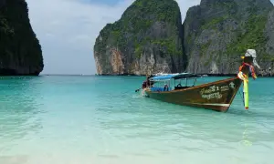 Łódź kołysze się na turkusowych wodach Maya Bay, otoczonej stromymi, porośniętymi zielenią klifami.