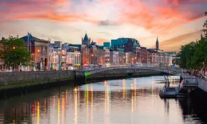 Zachód słońca nad rzeką Liffey, gdzie jest Dublin. Widać most Ha'penny i kolorowe kamienice.