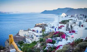 Santorini, Grecja. Czy do Grecji potrzebny jest paszport? Tak, jeśli nie jesteś obywatelem UE. Białe domy, niebieskie drzwi, morze.