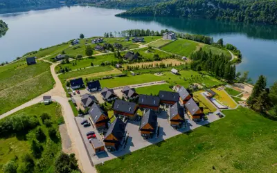 Osada domków letniskowych Grabowiec nad jeziorem, otoczona zielenią i lasami.