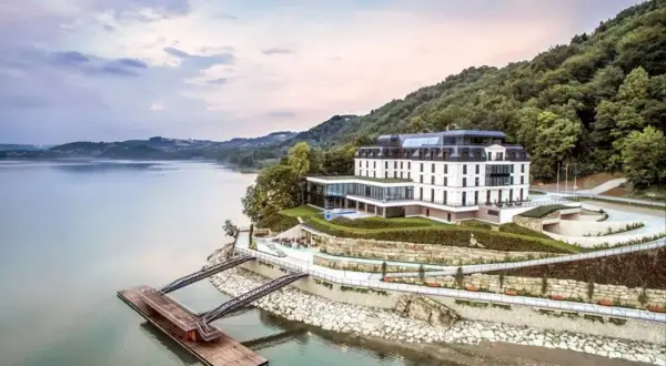 Nowoczesny hotel nad jeziorem, idealny na romantyczne miejsca w Polsce. Widok na wodę, las i pomost.