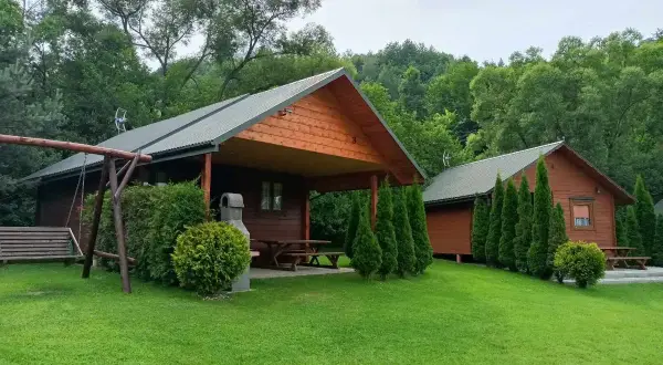 Drewniane domki w otoczeniu zieleni, idealne na wypoczynek w **bukowiec**. Huśtawka i grill zapraszają do relaksu.