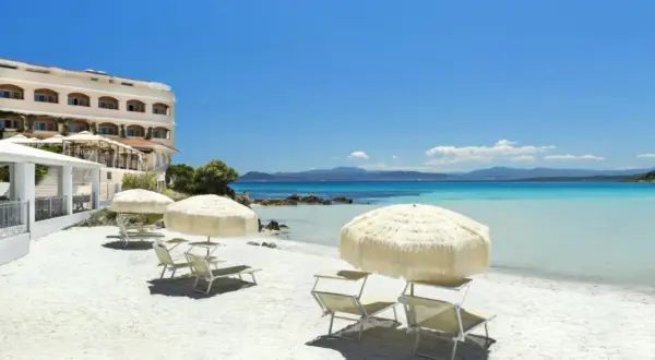 Rajska plaża na Sardynii. Biały piasek, turkusowa woda i hotel. Idealne miejsce na relaks.
