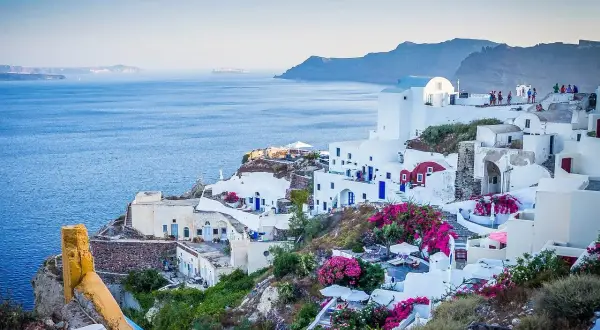 Santorini, Grecja. Czy do Grecji potrzebny jest paszport? Tak, jeśli nie jesteś obywatelem UE. Białe domy, niebieskie drzwi, morze.
