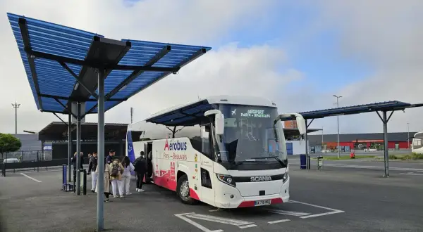 Autobus Aerobus Paris-Beauvais czeka na pasażerów pod niebieskim zadaszeniem.