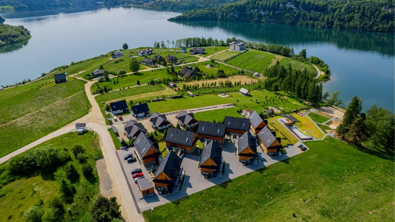 Osada domków letniskowych Grabowiec nad jeziorem, otoczona zielenią i lasami.