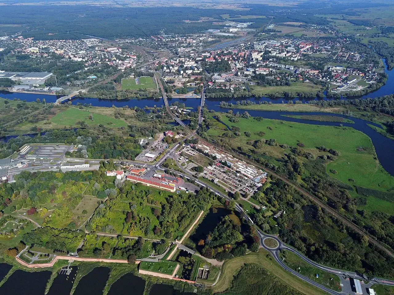 Widok z lotu ptaka na miasto Kostrzyn nad Odrą, rzekę, mosty i fortyfikacje.