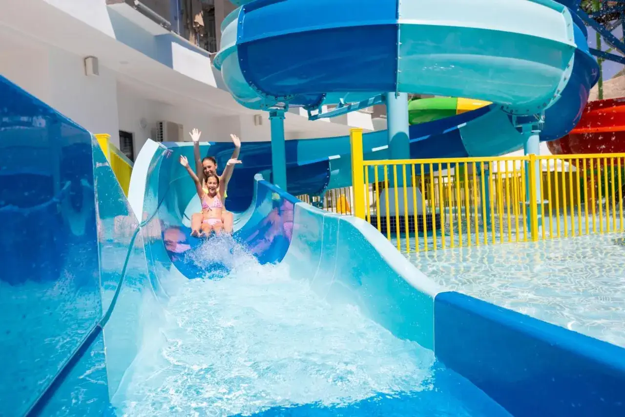 Radość na zjeżdżalni wodnej w hotelu Narcia Resort. Mama i córka ścigają się w dół, tworząc fale.