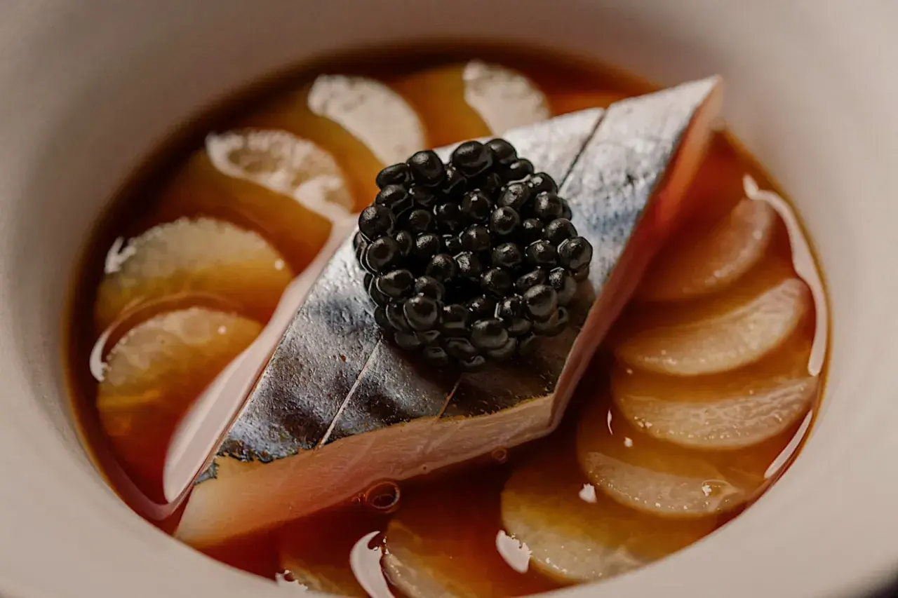 Wykwintne danie z rybą, kawior i plasterki warzyw w bulionie. Smaki, które można znaleźć w restauracjach z gwiazdką Michelin Polska.