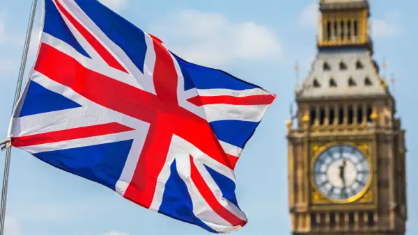 Flaga Wielkiej Brytanii powiewa przed Big Benem. Marzysz o podróży i potrzebujesz wiza do UK?