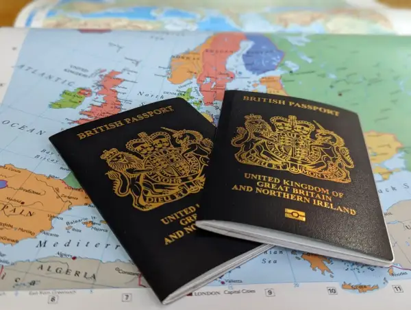 Dwa brytyjskie paszporty leżą na mapie Europy, sugerując podróż. Czy do Wielkiej Brytanii potrzebny jest paszport? Tak, dla większości podróżnych.