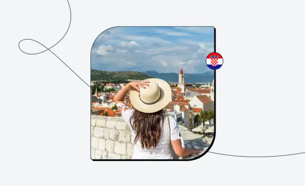 Kobieta w kapeluszu podziwia widok na chorwackie miasto. Chorwacja w strefie Schengen to marzenie wielu podróżników.