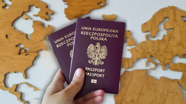 Dwa polskie paszporty w dłoni na tle mapy Europy. Zastanawiasz się, ile kosztuje paszport?