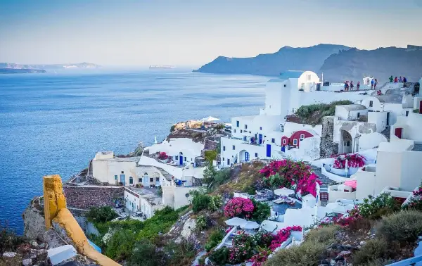 Santorini, Grecja. Czy do Grecji potrzebny jest paszport? Tak, jeśli nie jesteś obywatelem UE. Białe domy, niebieskie drzwi, morze.
