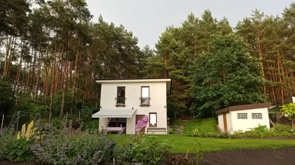 Nowoczesny dom w otoczeniu lasu, z kwitnącym ogrodem. Idealne miejsce na wypoczynek, jak w bajkowym Skarbimierzu.